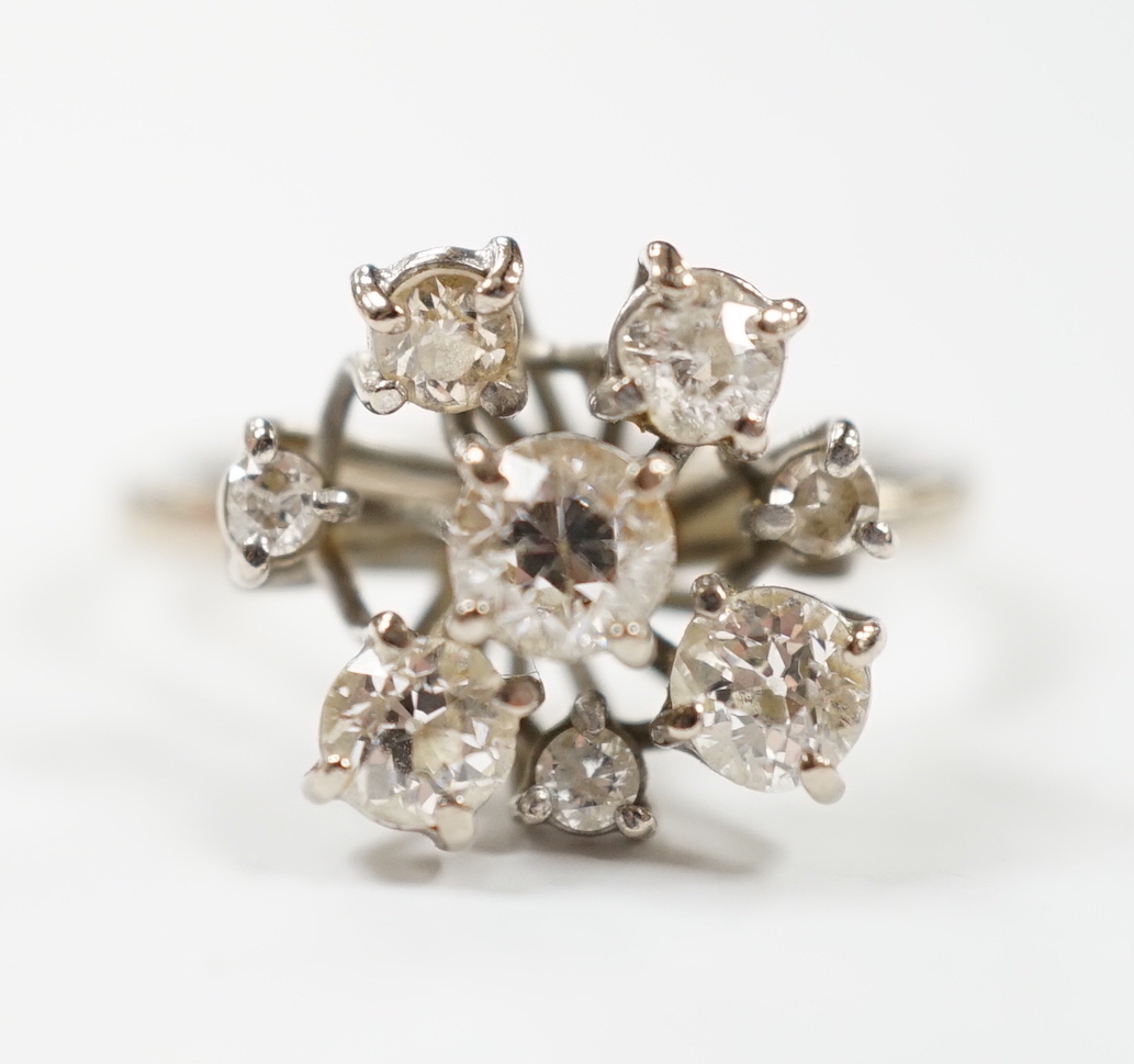 A modern 18ct white gold and graduated eight stone diamond cluster set dress ring, size S, gross weight 7 grams.